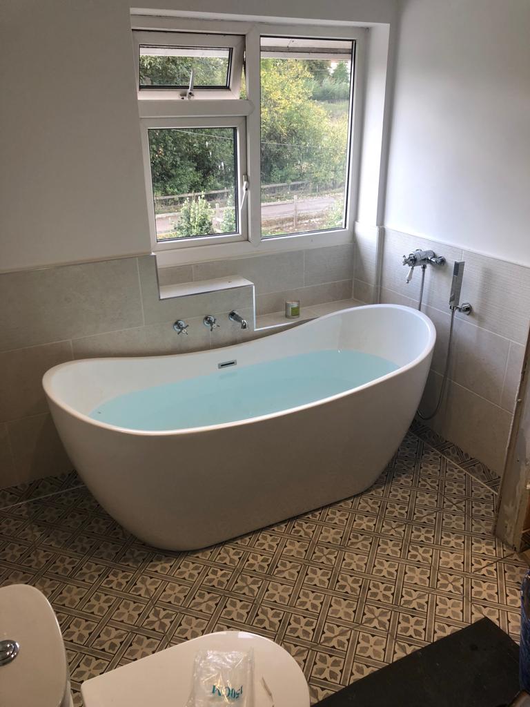 Free-standing bath installation with wall-mounted taps